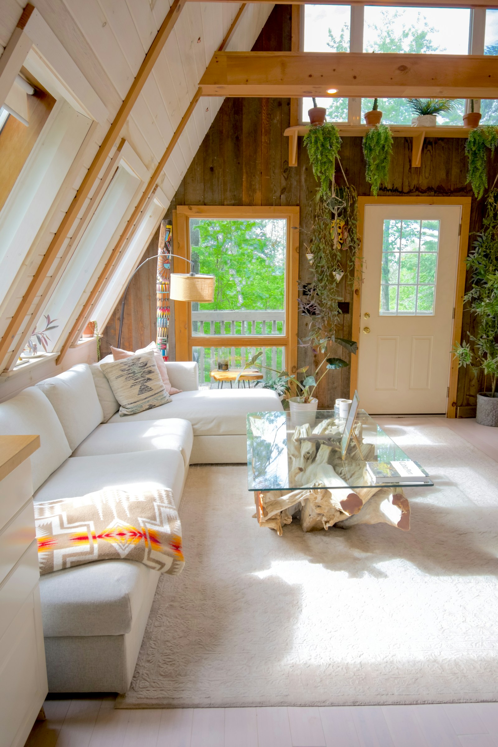 Natural light falling across a calm living room with white seating and warm timber